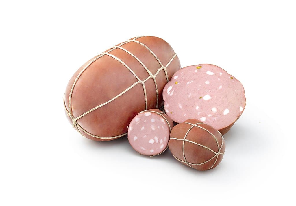 A sliced mortadella sausage with distinctive patterns and pink hue