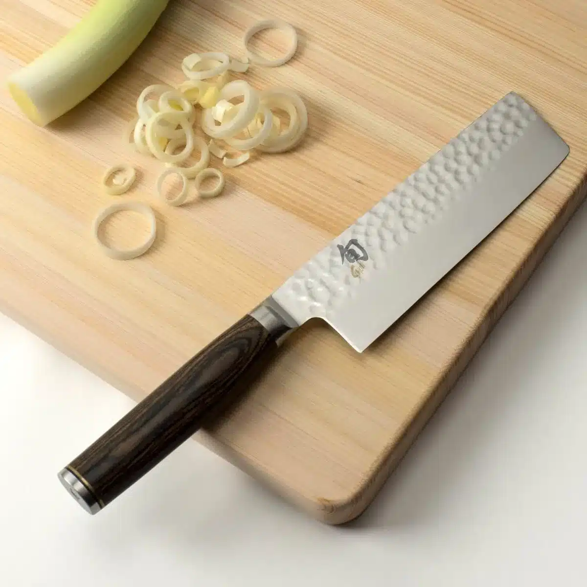 leeks with nakiri on cutting board