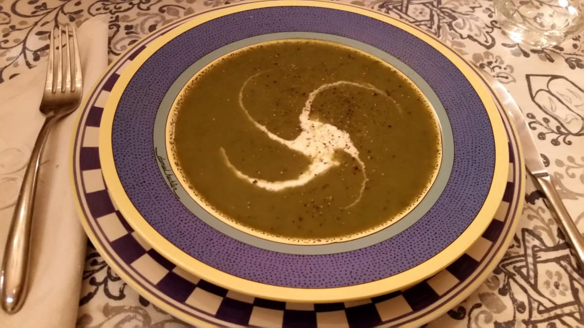 Bowl of green nettle soup with a cream swirl