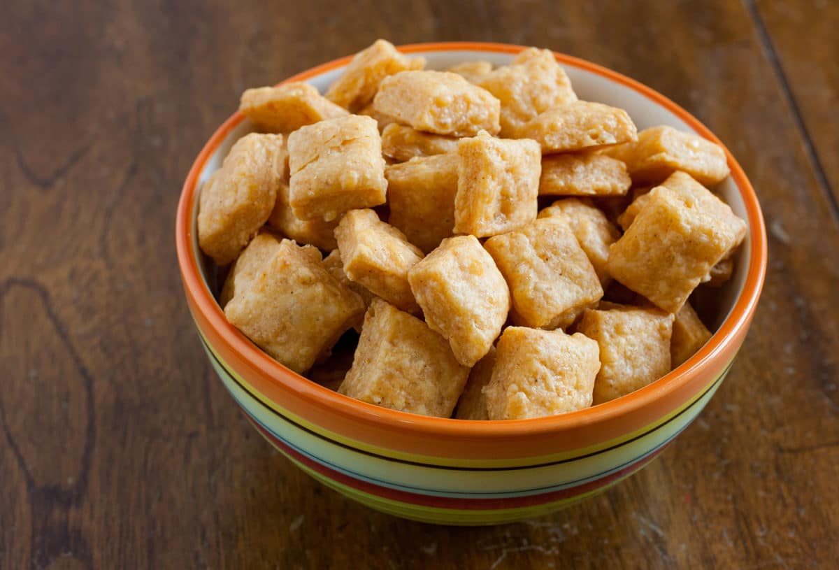 Bowl filled with bite-sized cheddar snacks.