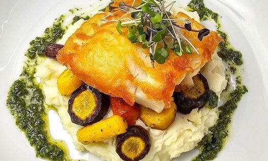 Pan seared sea bass on mashed potatoes with carrot top pesto