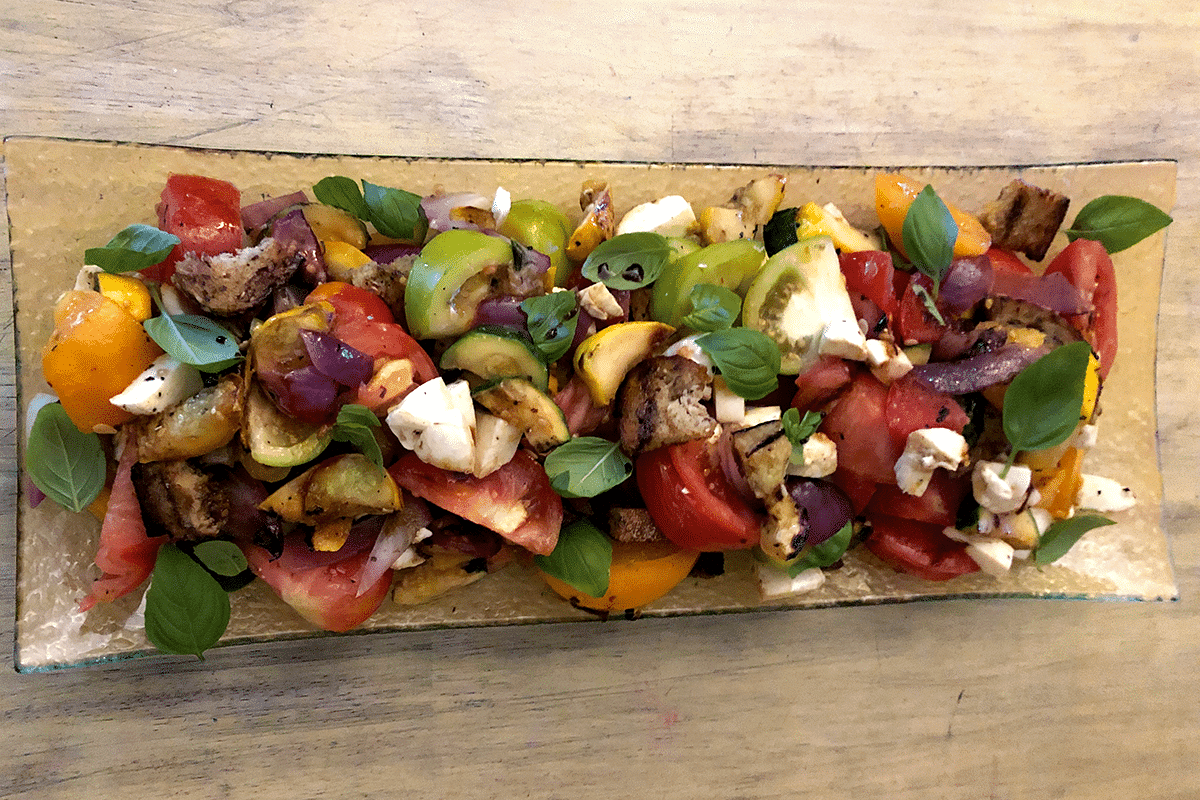 Detailed view of panzanella salad on a wooden platter