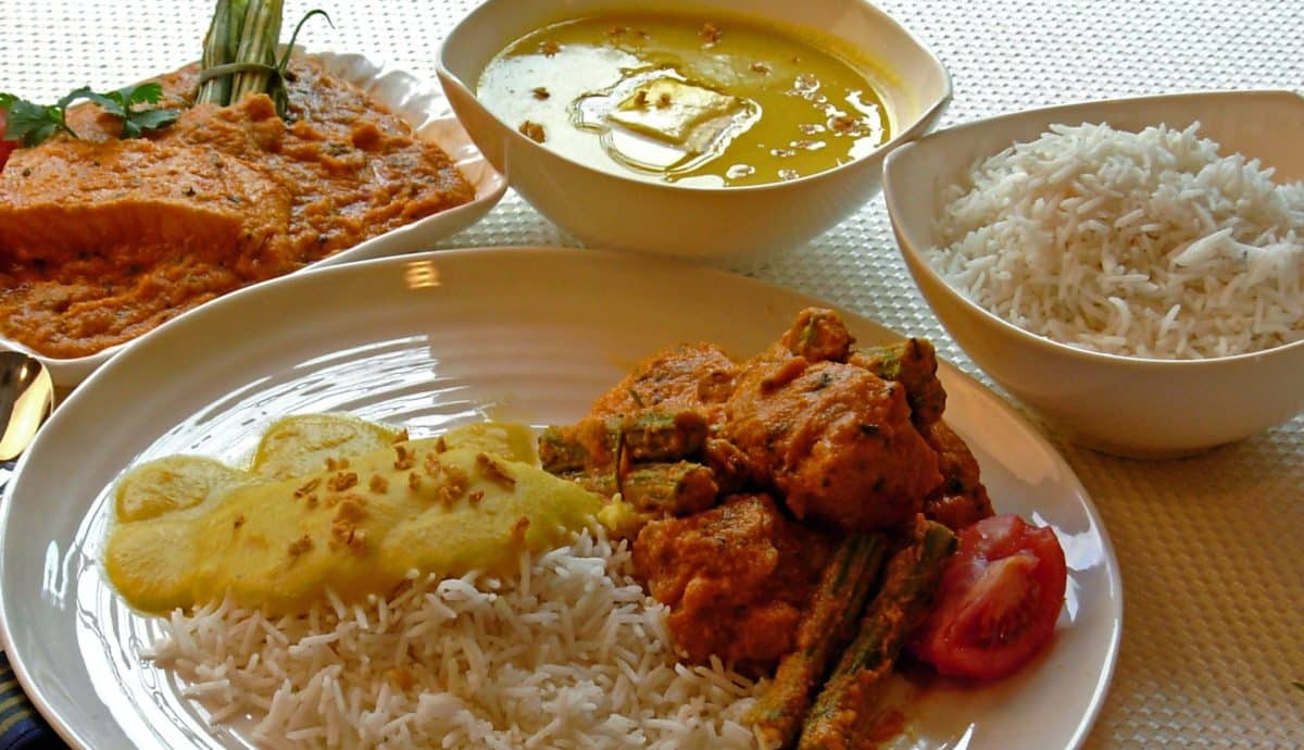 Traditional Parsi meal consisting of rice, curry, and various accompaniments.