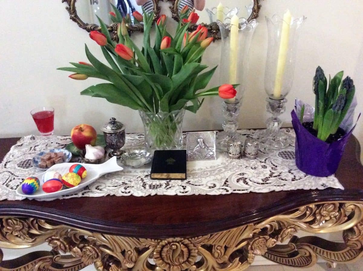 A decorated table with tulips, candles, and colorful festive items.