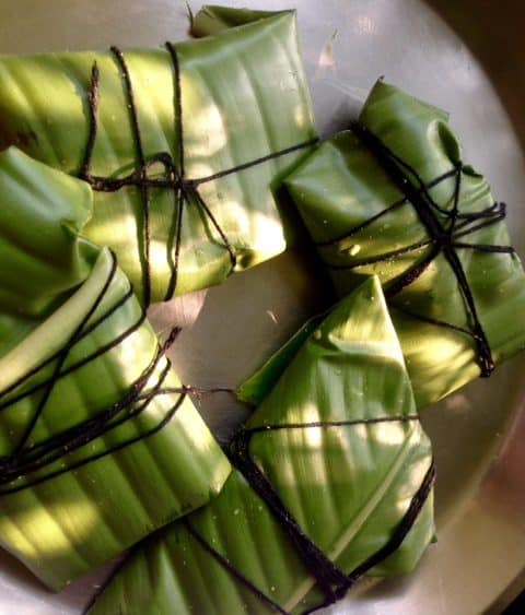 Green banana leaves wrapped in a parcel shape, tied with black string