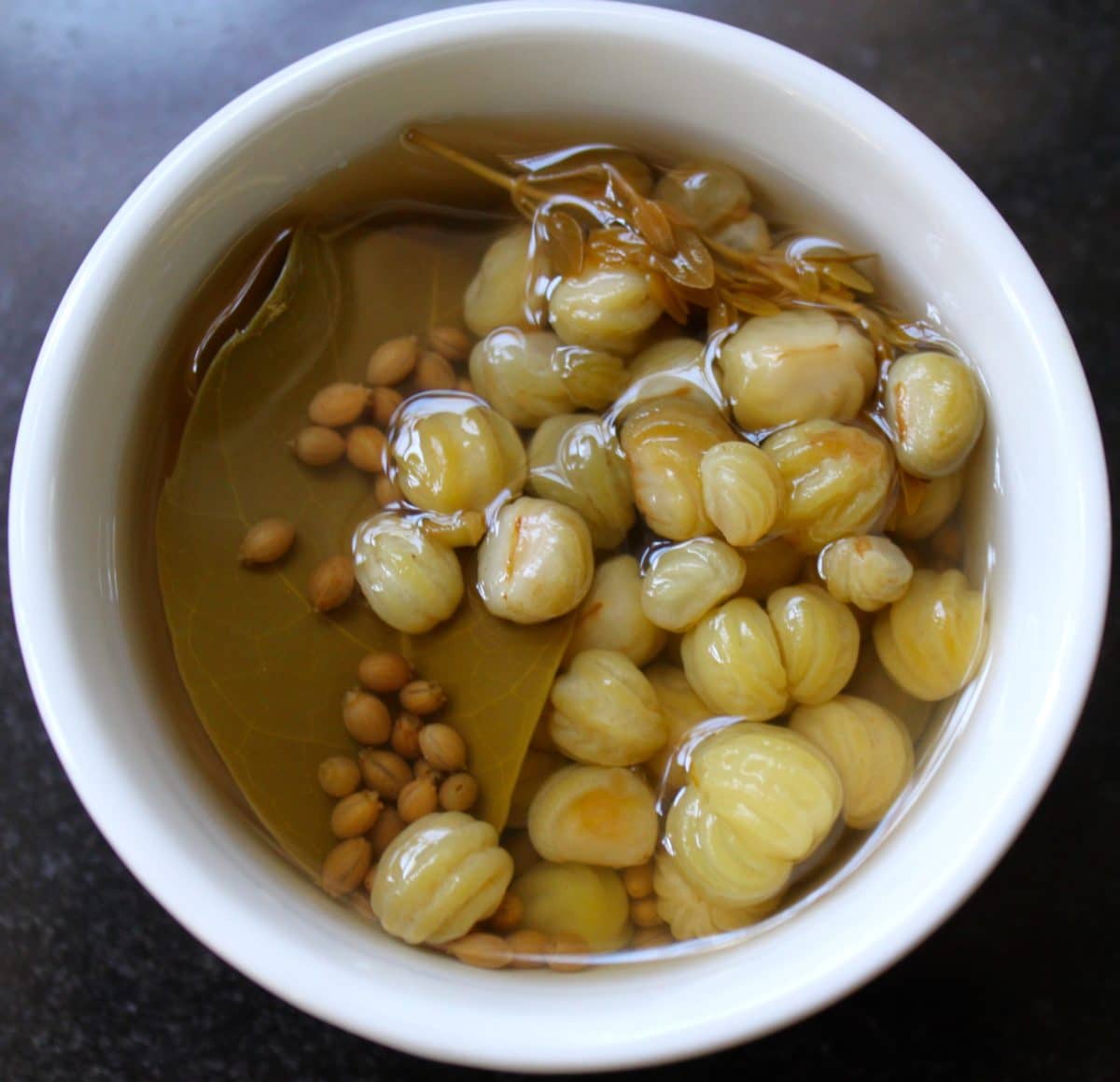 Bowl of pickled nasturtium capers in brine
