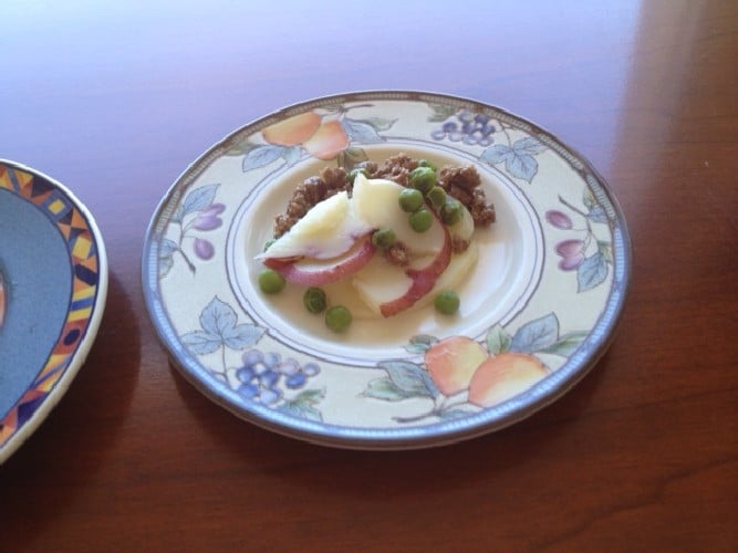 A decorative plate presenting Poached Tuna Treat for Cats, with a beautiful garnish.