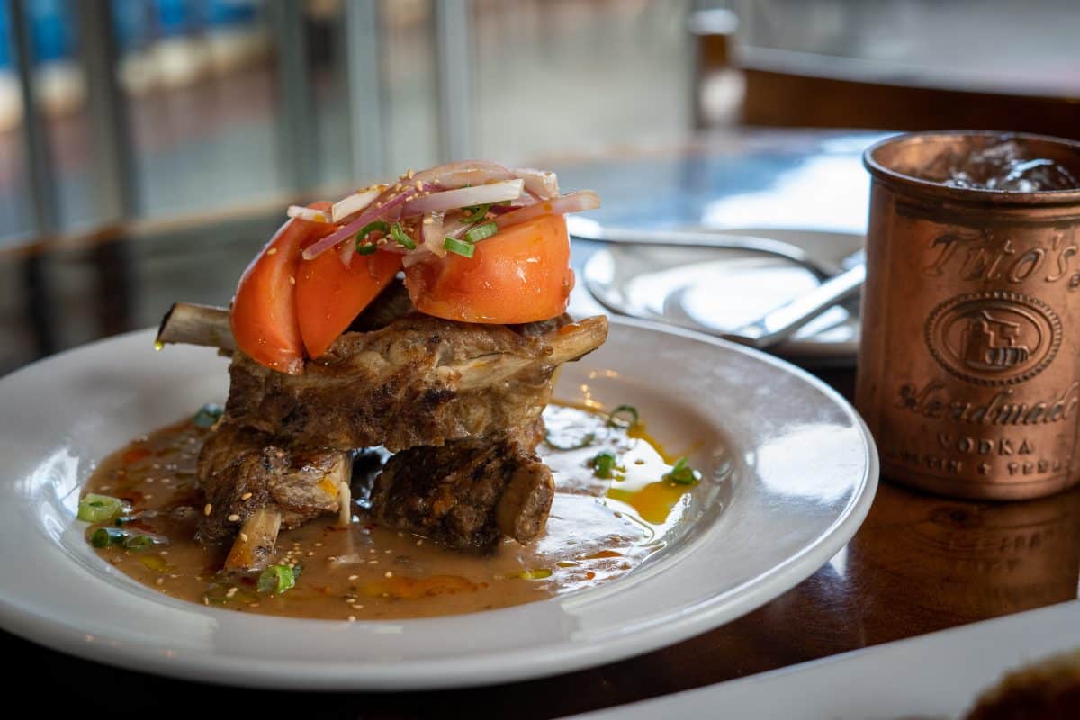 Pork Adobo topped with tomato on a plate