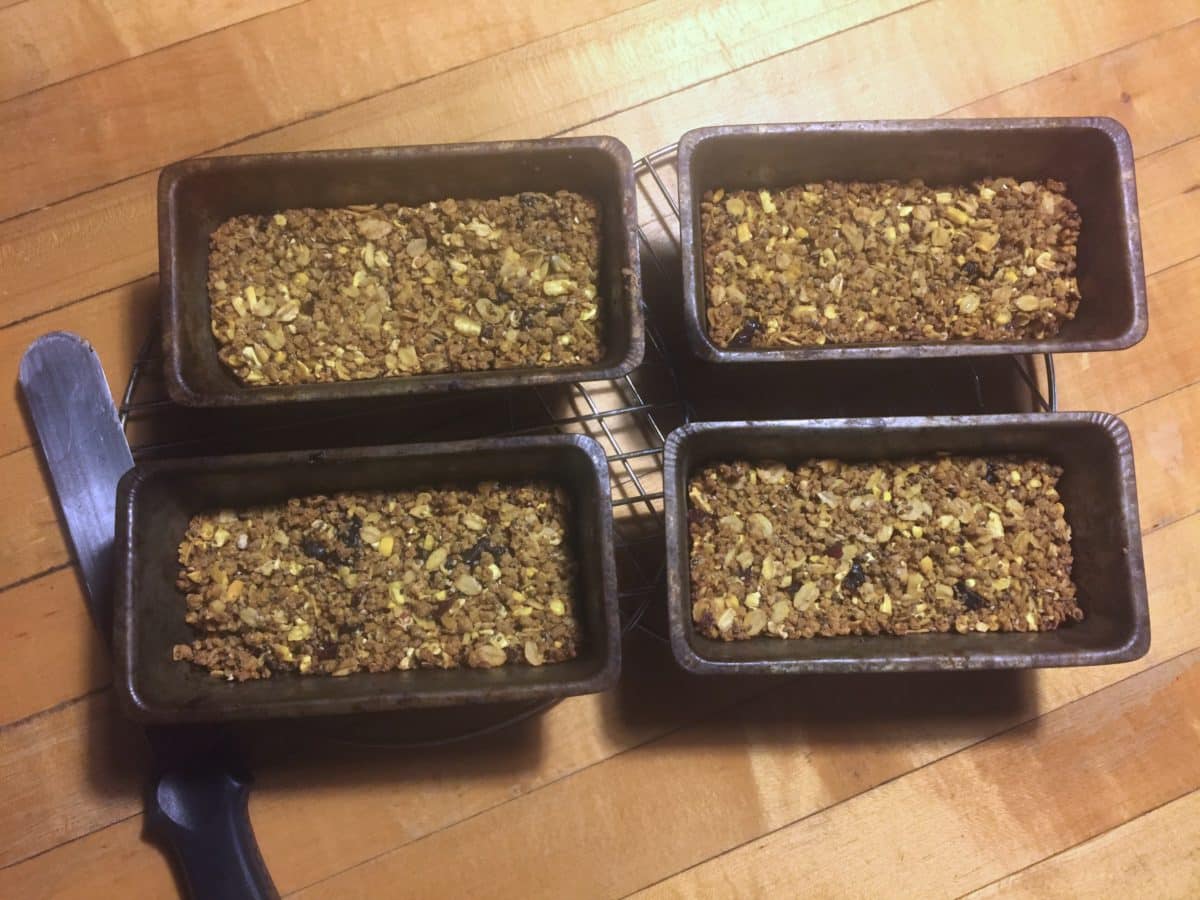 Four pans filled with compacted chicken treat mixture.