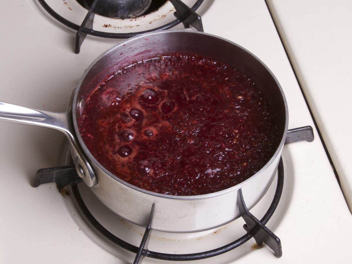 Bubbling saucepan with a dark red reduction