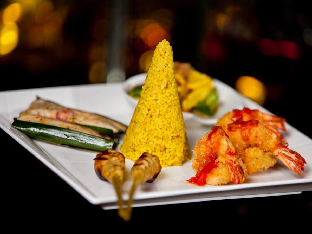 A vibrant dish from Rijsttafel featuring a yellow cone and prawns.