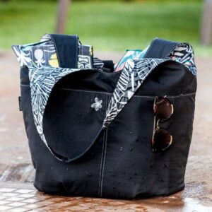 Black cargo tote with a patterned scarf and sunglasses. From the Ripskirt collection labeled 'WEARABLES'.