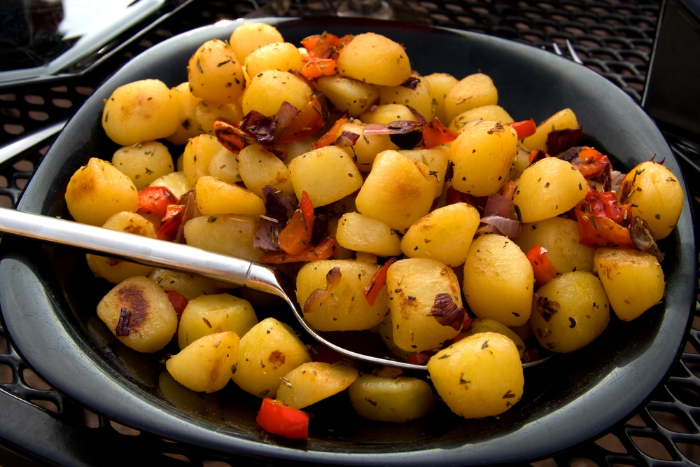 Close-up of roasted potatoes mixed with sweet pepper paste.