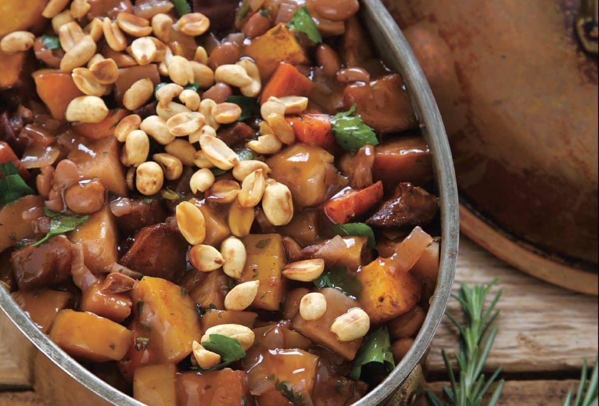 Close-up of a rustic stew with nuts, potatoes, and vegetables.