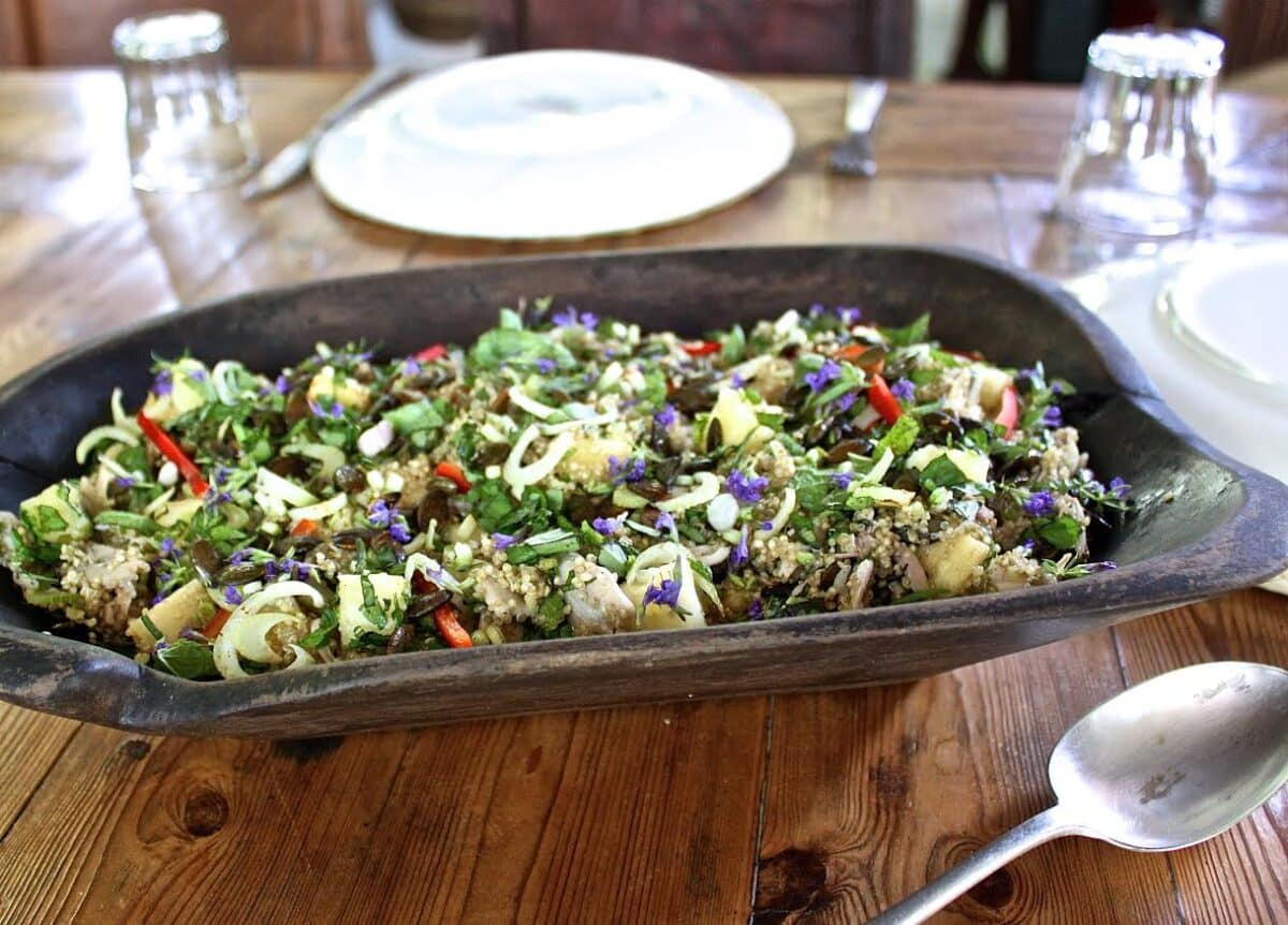 Close-up of a vibrant salad with various fresh ingredients on a rustic table.
