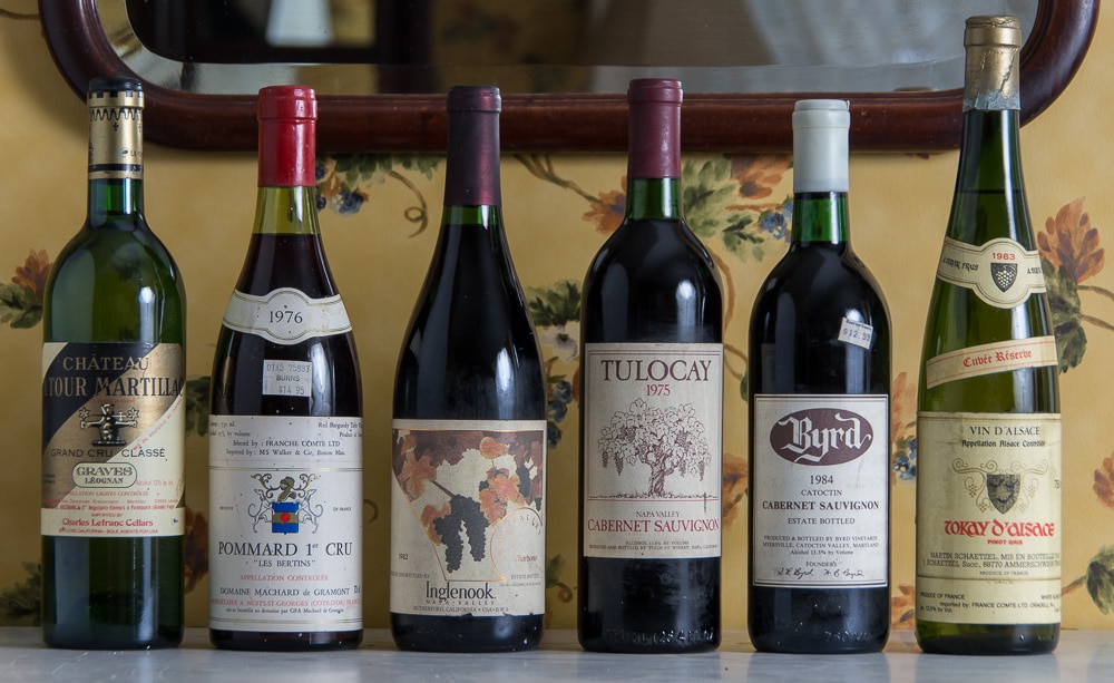 A collection of six diverse wine bottles on a table.