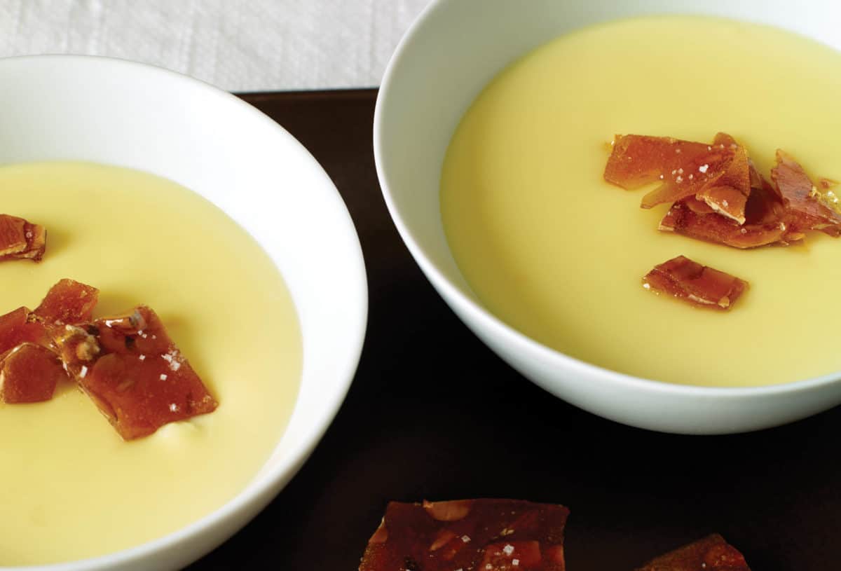 Two bowls of creamy saffron rice pudding garnished with caramelized bits