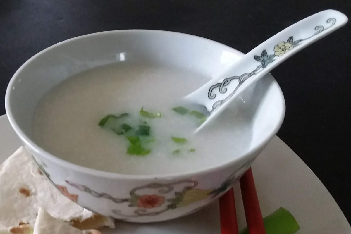 Close-up of a bowl of congee with green onion toppings