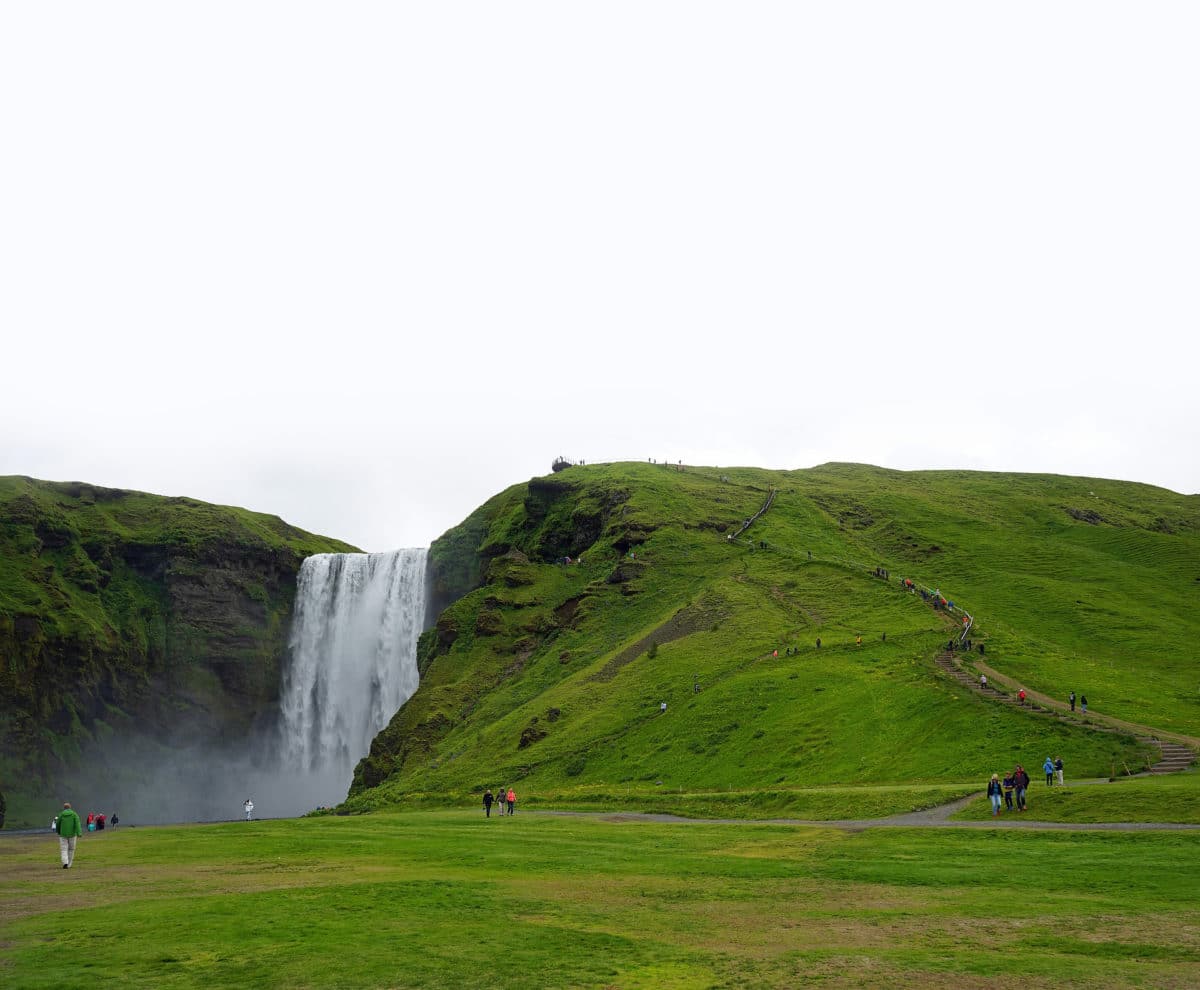 Majestic Skogafoss waterfall surrounded by green landscapes