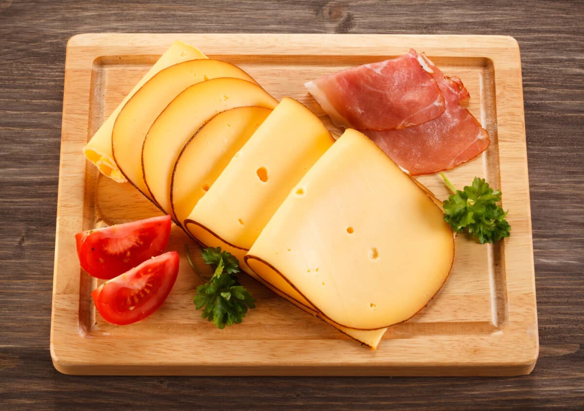 Sliced smoked gGouda cheese on cutting board
