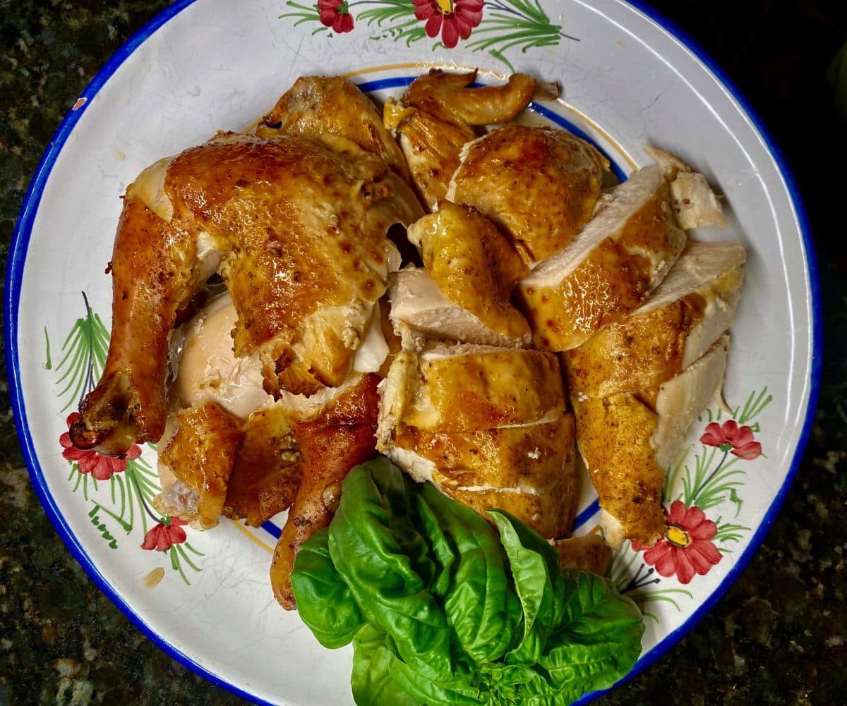 A plate with neatly sliced tea-smoked chicken alongside fresh lettuce
