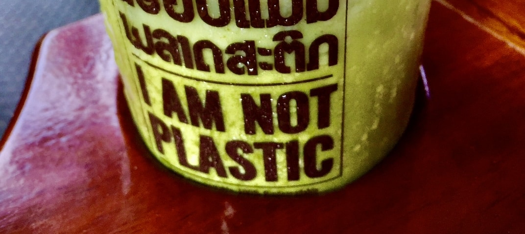 Close-up view of a green smoothie with a "I AM NOT PLASTIC" label.
