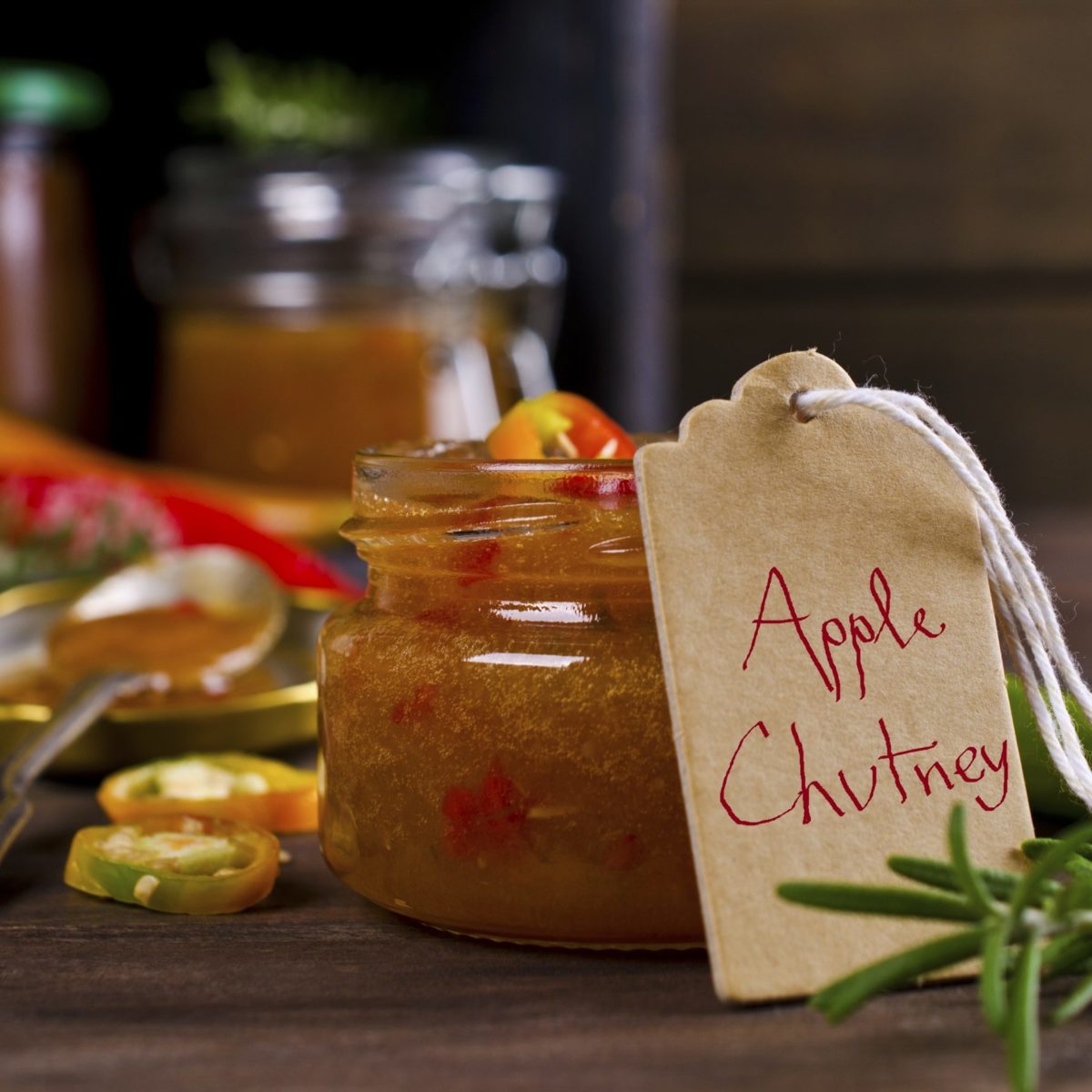 Apple chutney with hot peppers in a glass jar.
