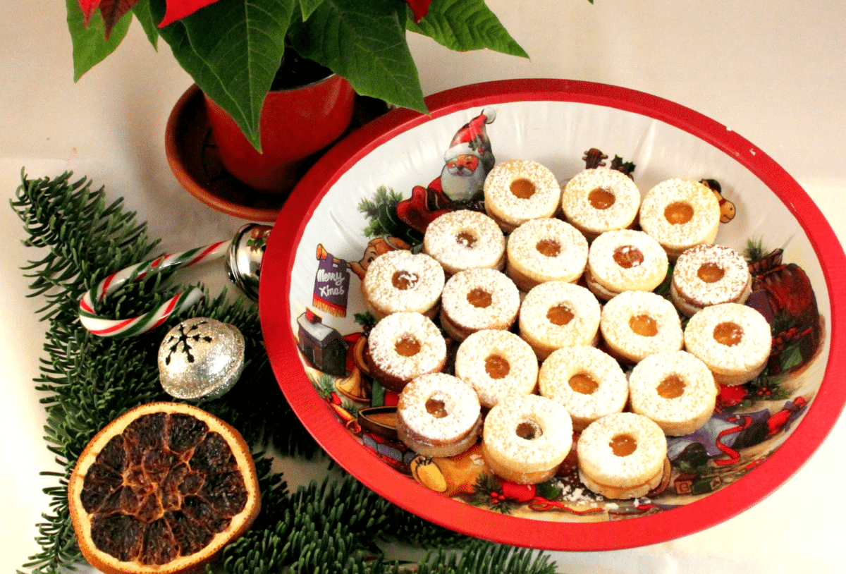Spitzbuben Swiss Christmas cookies on a festive red plate.