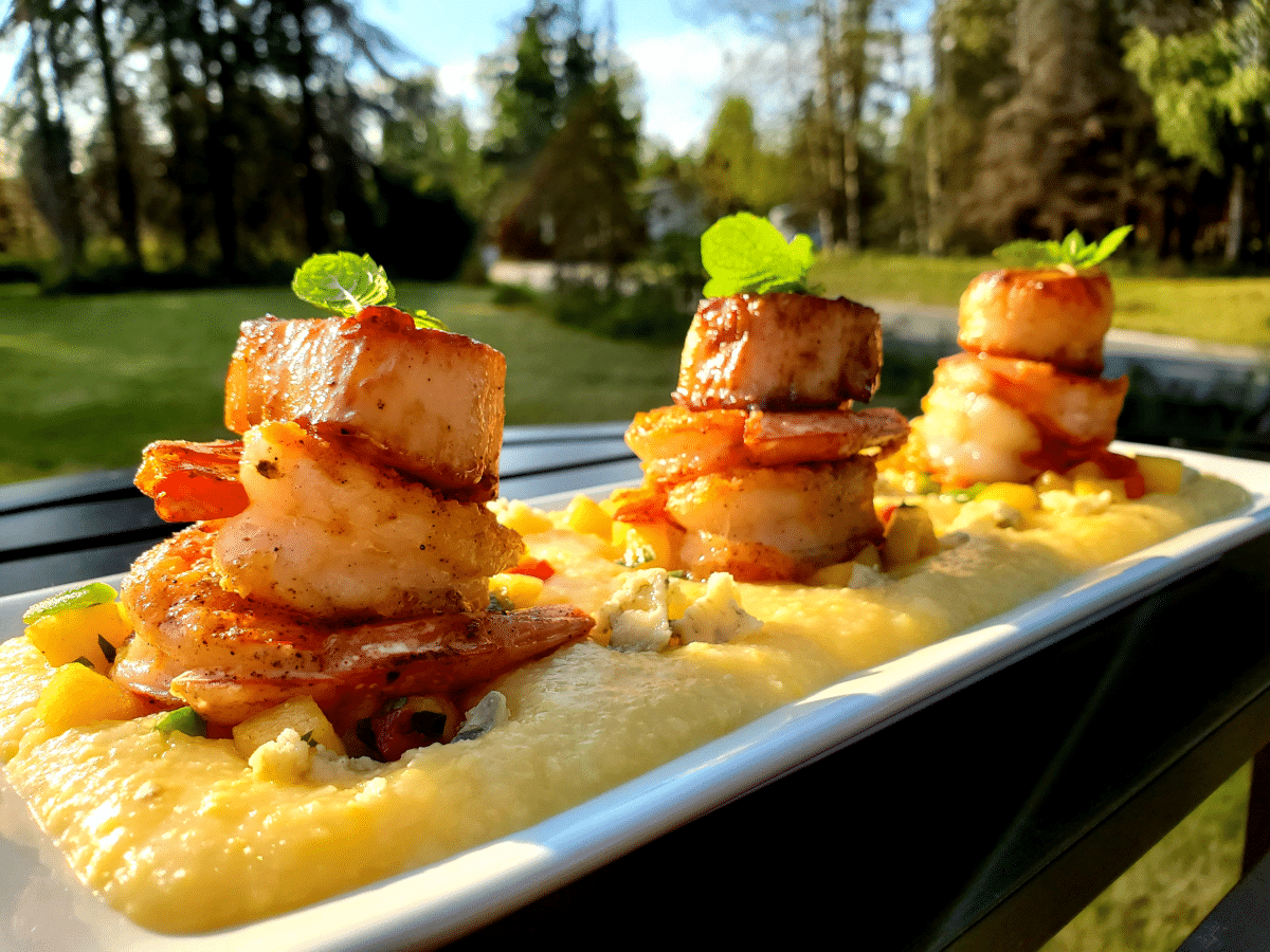 Towered shrimp on a bed of creamy grits with fresh herbs and spices.