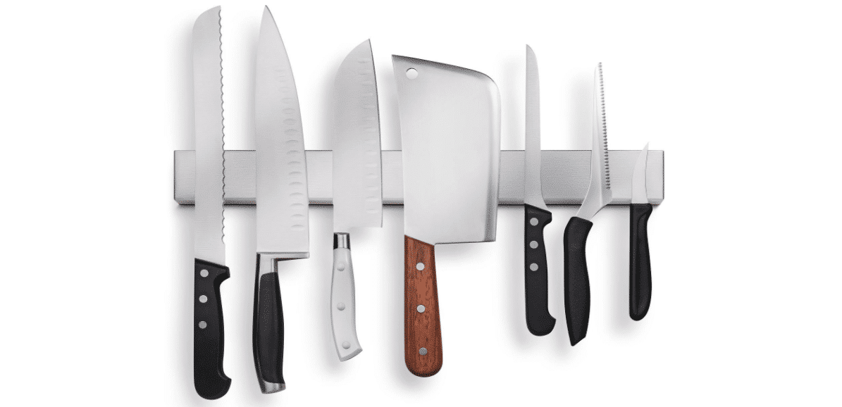 Several knives attached to a stainless steel magnetic holder.