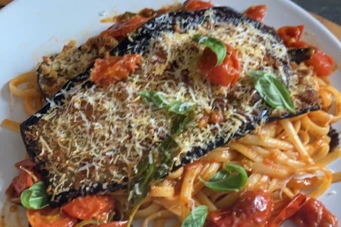 Dish of eggplant parmesan with tomatoes and cheese