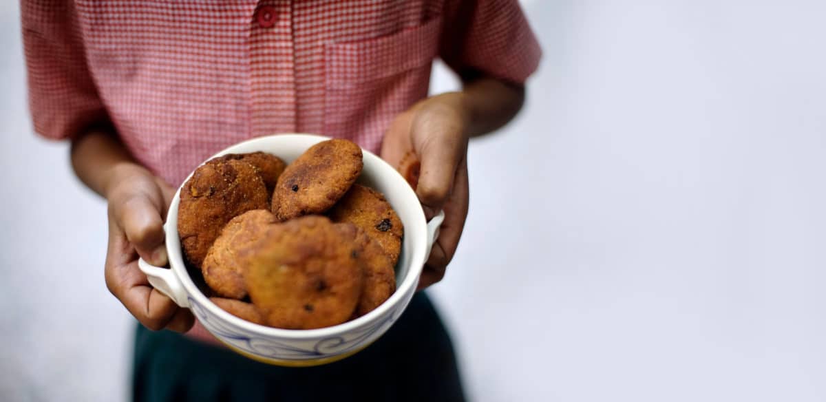 Man holding a bowl of Thékuā cookies