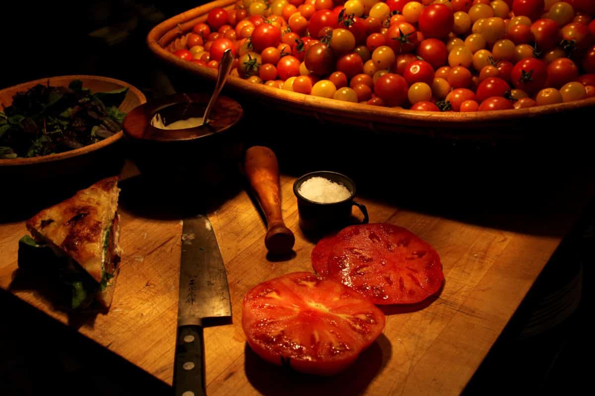 Close-up of freshly sliced tomatoes on a wooden cutting board. Photo credit: Jacinda Martinez