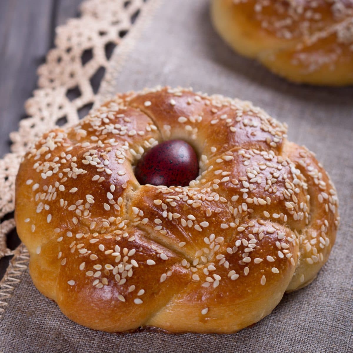 Tsoureki, a traditional Greek Easter bread with a red egg in the center, sprinkled with sesame seeds