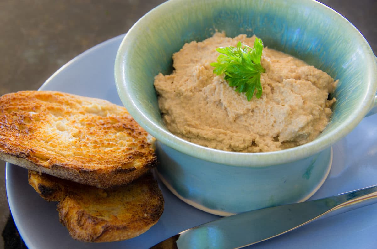 Spuma di Tonno (tuna mousse) served in a blue bowl with toasts alongside.