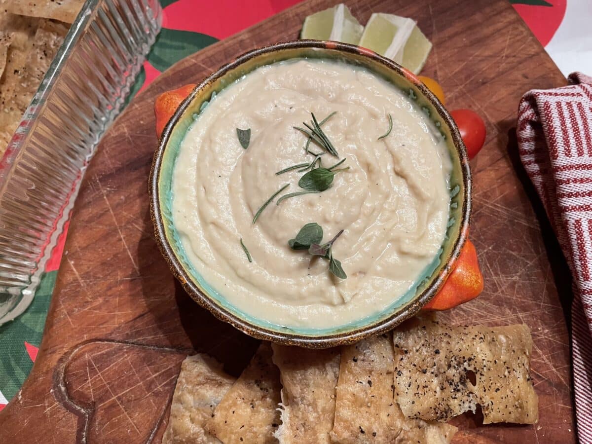 white bean dip in dish on board