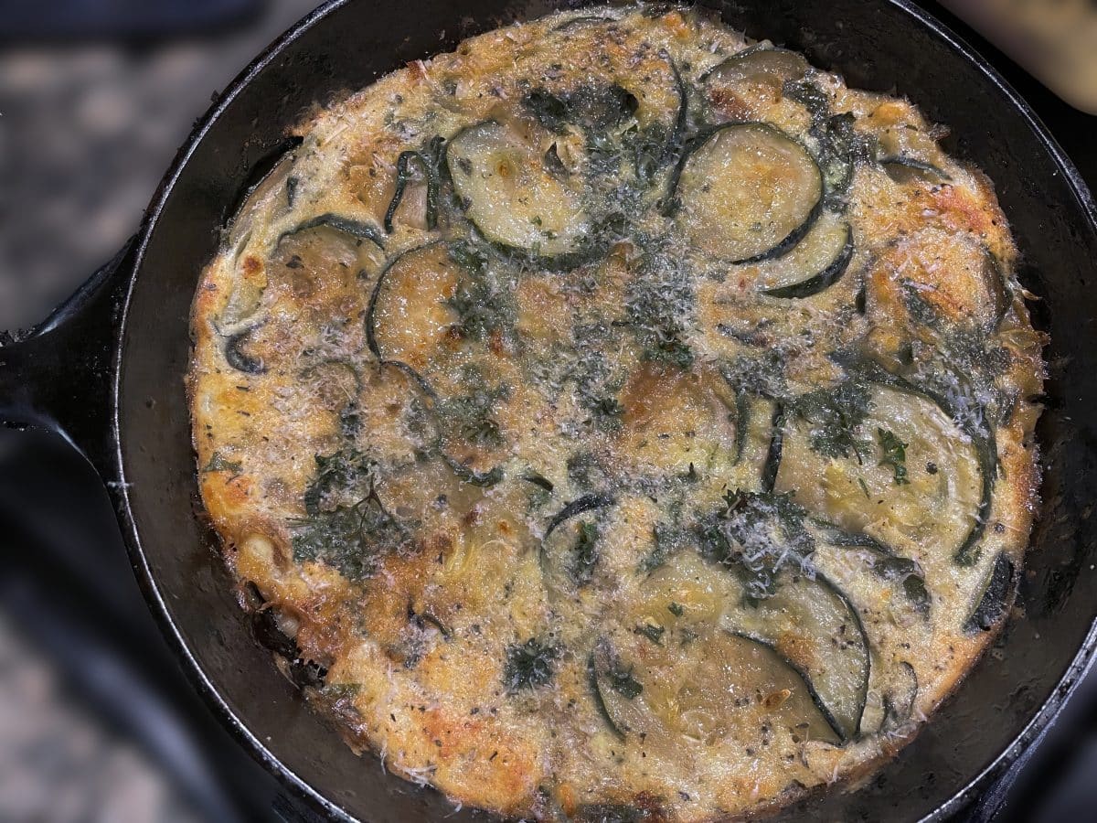 Baked zucchini slices with feta in a skillet.